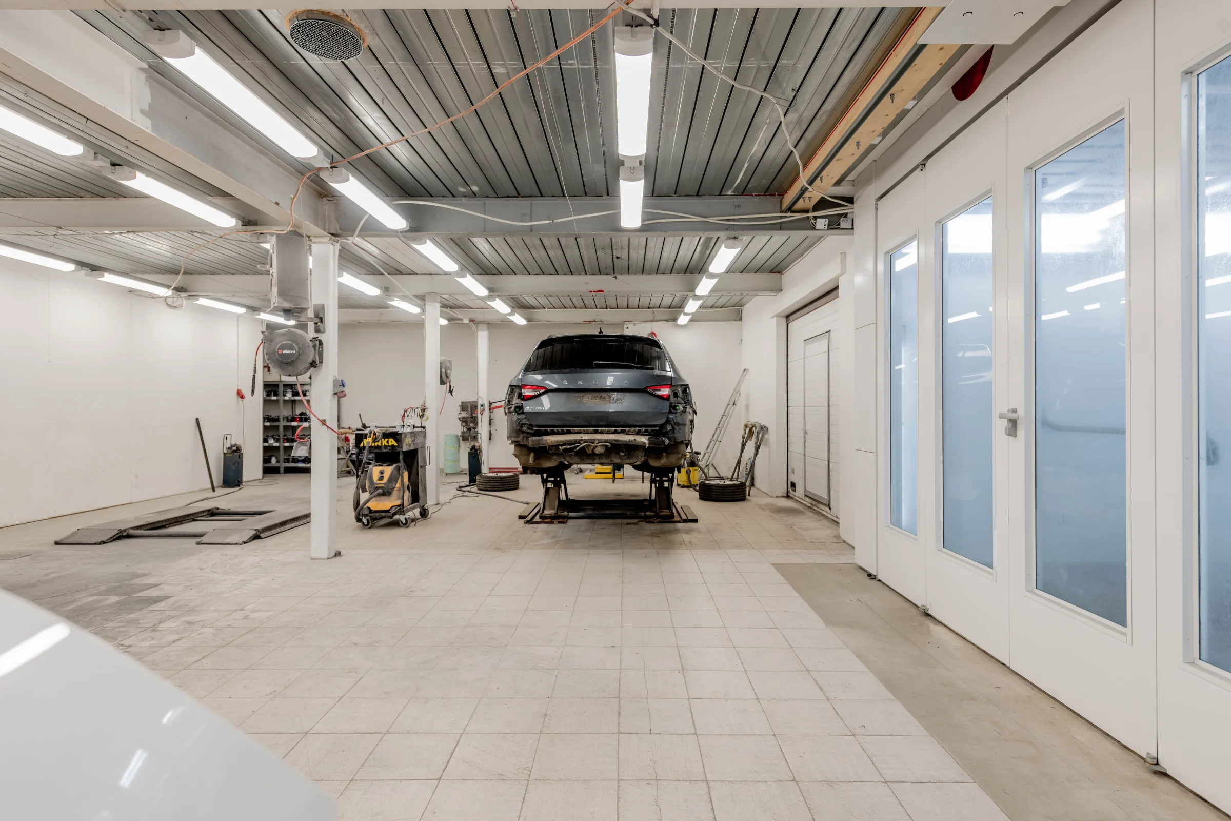 Vue de l'atelier de reprise avec un vehicule en cours d'expertise